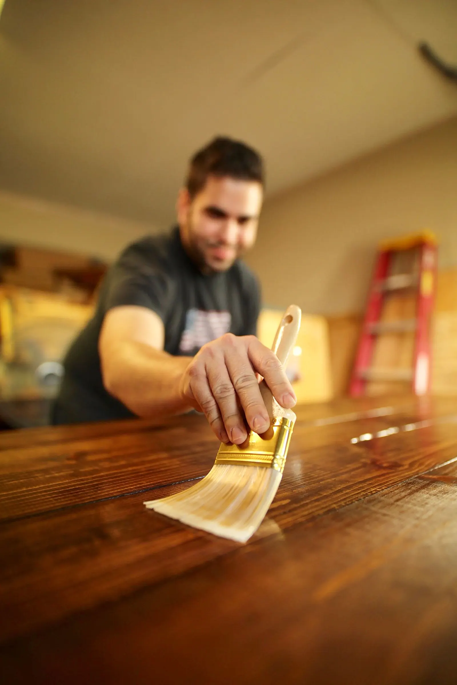 Person applying a wood finish with a brush